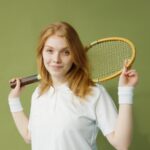 A Young Woman Holding a Squash Racket over her Shoulders