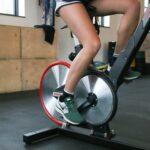 Person exercising on cycling machine in gym