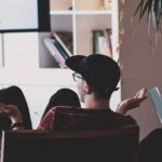 man in black shirt and black hat sitting on black chair