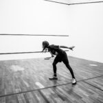 grayscale photography of person holding racket