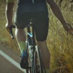 man in black shorts riding bicycle on road during daytime